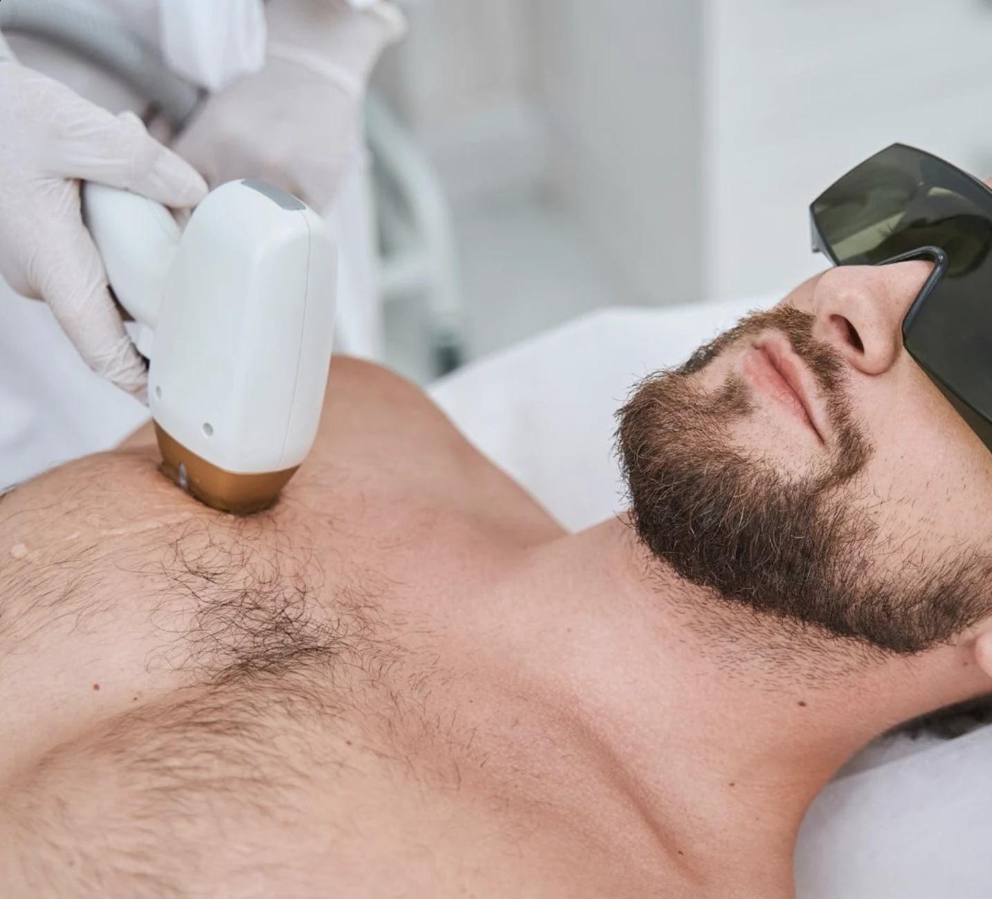 Laser hair reduction treatment being performed on a man's chest