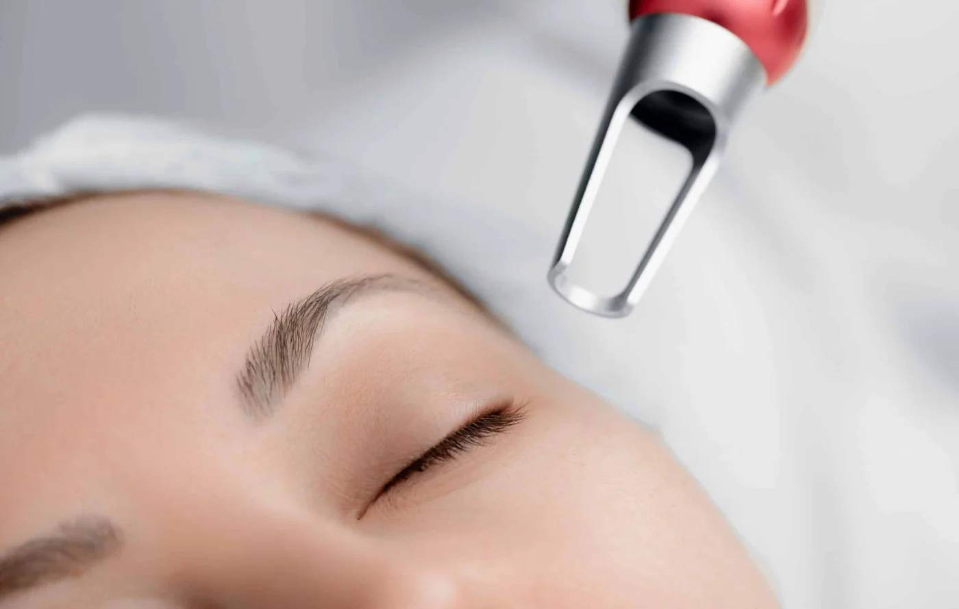 Pico laser handpiece positioned above facial skin